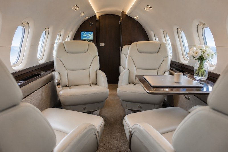 Luxury midsize jet cabin interior with leather club seating layout inside a Hawker 800XP private aircraft